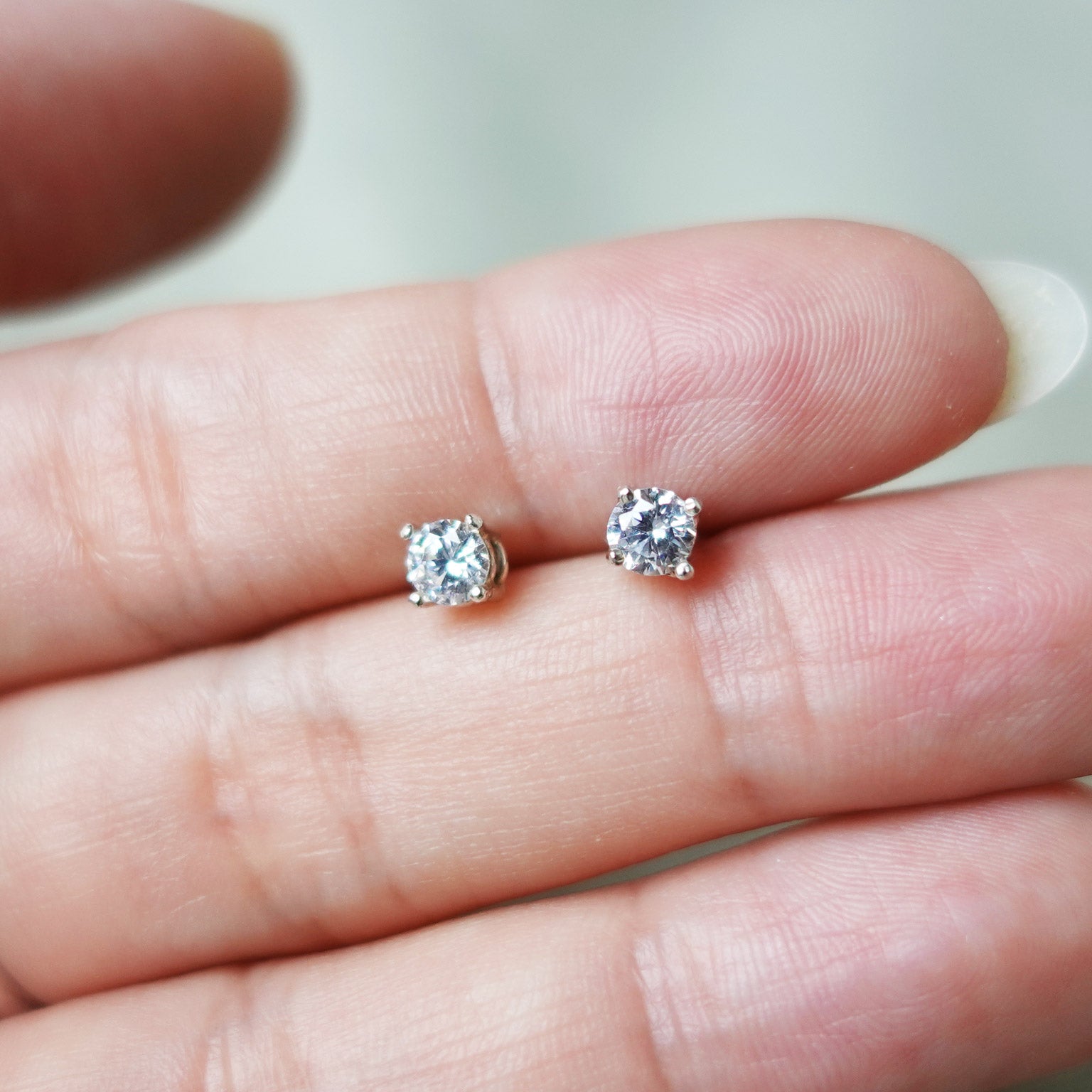Zircon Stud Earrings in White Hand