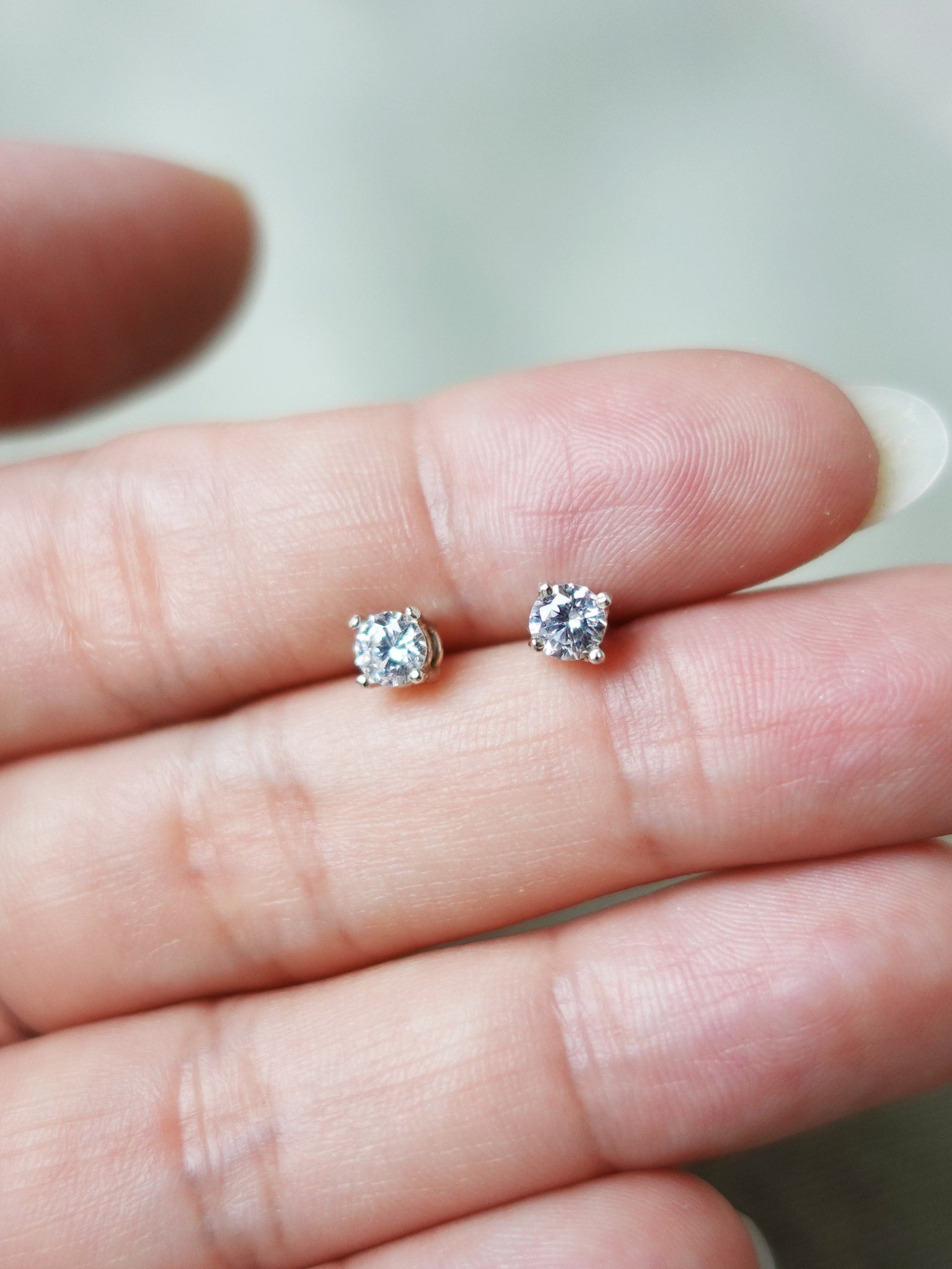 Zircon Stud Earrings in White Hand