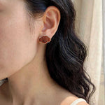 Brown poodle stud earrings on model