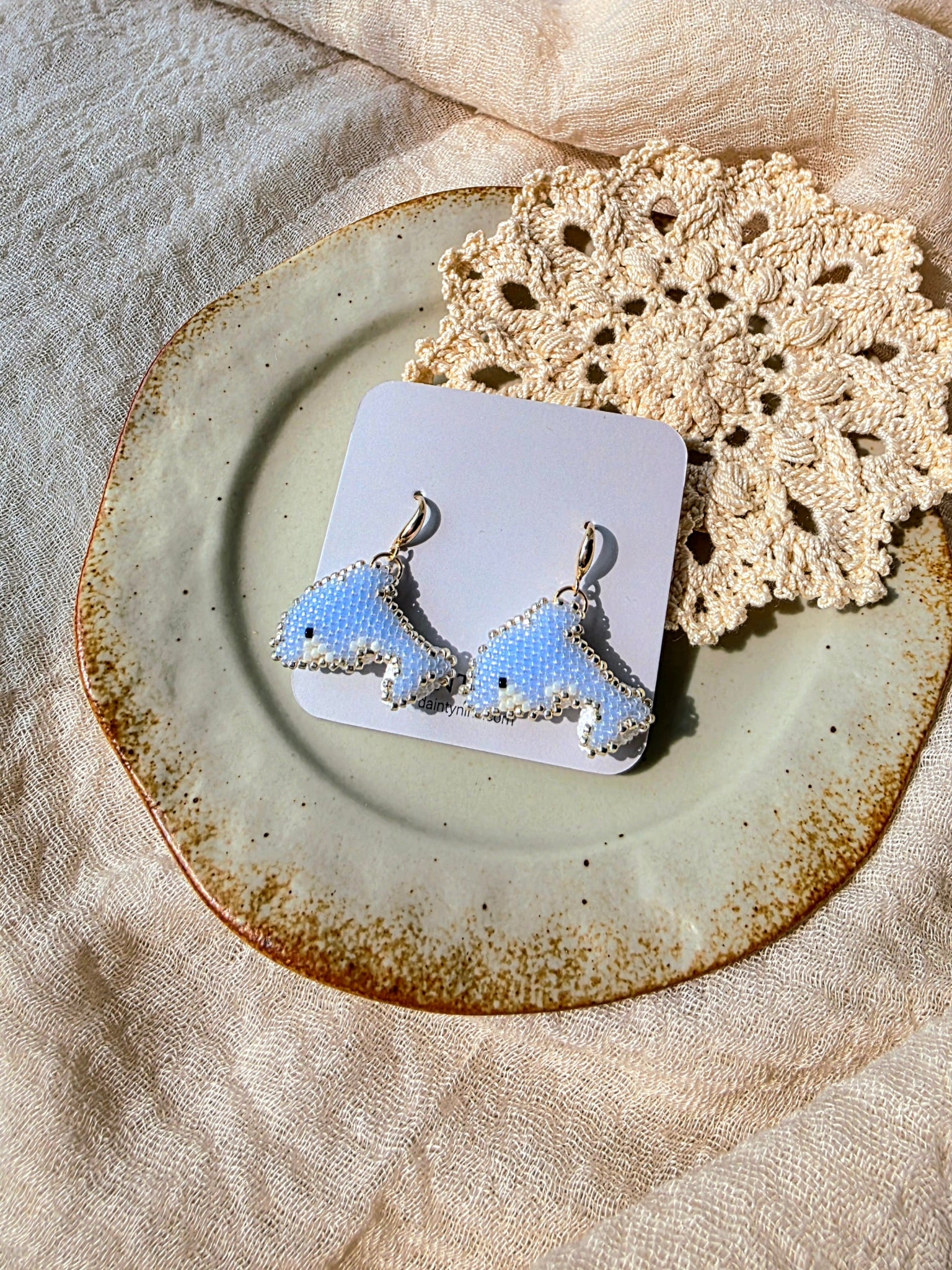 Dolphin drop earrings on card
