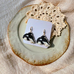 Killer whale drop earrings on card