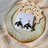 Killer whale drop earrings on card