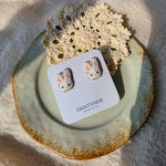 White bunny stud earrings on card