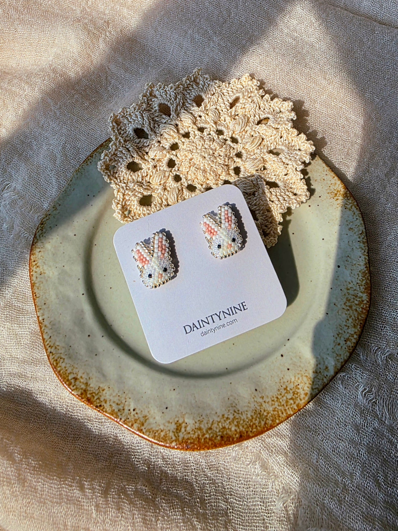 White bunny stud earrings on card